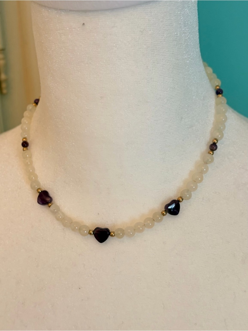 Handmade Cream Bead Necklace with Purple Heart Accents and gold beads.